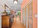 Hallway featuring a wooden dresser, closet with louvered doors, and a glimpse into a living room at 2571 Ames Haven Rd, Kissimmee, FL 34744
