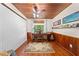 Bright home office with wood-paneled walls, ceiling fan, ample natural light, and hardwood floors at 2571 Ames Haven Rd, Kissimmee, FL 34744