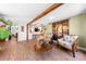 Open concept living room with hardwood floors, exposed beams, and comfortable seating arrangement with natural lighting at 2571 Ames Haven Rd, Kissimmee, FL 34744