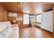 Cozy living room with wood-paneled walls, comfortable seating, and natural light for relaxation and entertainment at 2571 Ames Haven Rd, Kissimmee, FL 34744