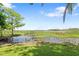 Scenic view of the pond with lily pads and natural vegetation, bordering the lush green lawn at 2571 Ames Haven Rd, Kissimmee, FL 34744