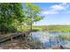 Tranquil view of the pond featuring a weathered dock and a variety of natural vegetation at 2571 Ames Haven Rd, Kissimmee, FL 34744