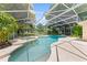 Inviting screened-in pool area with a spa, lush landscaping, and a tranquil setting for outdoor enjoyment at 2571 Ames Haven Rd, Kissimmee, FL 34744