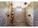 Luxurious walk-in shower with dual shower heads, intricate tile work, and a built-in niche for storage at 2571 Ames Haven Rd, Kissimmee, FL 34744