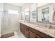Bathroom featuring double sinks, granite counters, updated fixtures, and glass shower at 2621 Redblush Ter, St Cloud, FL 34772