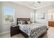 Bedroom with ceiling fan, neutral paint, two large windows and ensuite bathroom at 2621 Redblush Ter, St Cloud, FL 34772