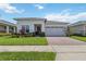 Charming single-story home with a well-maintained lawn and a brick driveway leading to a two-car garage at 2621 Redblush Ter, St Cloud, FL 34772