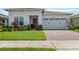 Charming home featuring a manicured lawn, brick paver driveway, and two-car garage at 2621 Redblush Ter, St Cloud, FL 34772