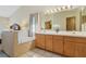 Bright bathroom featuring a soaking tub, double sink vanity, and large mirror at 2626 Gentre St, Kissimmee, FL 34744