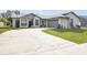 Charming single-story home with manicured lawn and long driveway leading to a two-car garage at 2626 Gentre St, Kissimmee, FL 34744