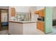 Bright kitchen with wooden cabinets, a breakfast bar, and a view into the living room at 2626 Gentre St, Kissimmee, FL 34744