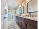 Bathroom with double sink vanity, granite countertops, dark cabinets and walk-in shower at 2669 Sand Hill Point Cir, Davenport, FL 33837