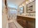 Elegant bathroom features double vanity, decorative mirrors, and stylish geometric shower curtain at 2669 Sand Hill Point Cir, Davenport, FL 33837