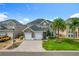 Beautifully landscaped front yard featuring a two-story home with a stone facade and a three-car garage at 2669 Sand Hill Point Cir, Davenport, FL 33837