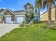 Two-story home with a lush lawn, a stone facade, and a convenient three-car garage at 2669 Sand Hill Point Cir, Davenport, FL 33837