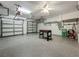 Spacious three-car garage featuring epoxy flooring and an organized layout for storage and activities at 2669 Sand Hill Point Cir, Davenport, FL 33837