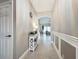 Inviting hallway with neutral paint, chair railing, and views into the living room at 2669 Sand Hill Point Cir, Davenport, FL 33837