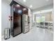 Open kitchen view, featuring stainless steel refrigerator, large cabinet, and view into the dining room at 2669 Sand Hill Point Cir, Davenport, FL 33837