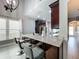 Kitchen island with gray stools, granite counter tops, and stainless appliances with a full view of the dining room at 2669 Sand Hill Point Cir, Davenport, FL 33837