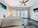 Bright main bedroom with a ceiling fan, balcony access, and herringbone flooring at 2669 Sand Hill Point Cir, Davenport, FL 33837