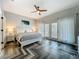Airy main bedroom with balcony, herringbone floors, and white bedside tables at 2669 Sand Hill Point Cir, Davenport, FL 33837