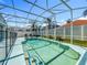 A private pool is surrounded by a screened enclosure, lush landscaping, and seating area at 2669 Sand Hill Point Cir, Davenport, FL 33837