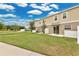 Backyard view of the green lawn and white fence and the building exterior at 2690 Pleasant Cypress Cir, Kissimmee, FL 34741