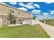 Backyard view showing the exterior, green grass, and white fence at 2690 Pleasant Cypress Cir, Kissimmee, FL 34741