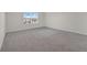 Bright, carpeted bedroom featuring a large window with a view at 2690 Pleasant Cypress Cir, Kissimmee, FL 34741
