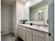 Bathroom featuring double sinks, a large mirror, and neutral-toned cabinets at 2727 Harmonia Hammock Rd, Harmony, FL 34773