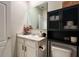 Bathroom with vanity, mirror, black cabinet, and toilet, offering a clean and functional space at 2727 Harmonia Hammock Rd, Harmony, FL 34773