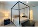 Cozy bedroom with four-poster bed, bedside table and lamp, and bench seating at 2727 Harmonia Hammock Rd, Harmony, FL 34773