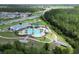 The community clubhouse overlooks the resort-style pool, a playground, a pier, and surrounding natural landscape at 2727 Harmonia Hammock Rd, Harmony, FL 34773