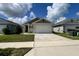 Beautifully landscaped front yard features green grass and tasteful plantings, enhancing the home's curb appeal at 2727 Harmonia Hammock Rd, Harmony, FL 34773