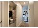 Hallway view leading to a bathroom with floral shower curtain and framed photos on the wall at 2727 Harmonia Hammock Rd, Harmony, FL 34773