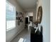 Bright hallway view with a large mirror, gallery wall, and natural light streaming through the window at 2727 Harmonia Hammock Rd, Harmony, FL 34773