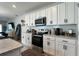 Bright kitchen showcasing stainless steel appliances, white cabinets, and ample counter space at 2727 Harmonia Hammock Rd, Harmony, FL 34773