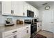 Kitchen view featuring stainless steel appliances, white cabinetry, and tiled backsplash at 2727 Harmonia Hammock Rd, Harmony, FL 34773