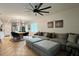 Bright living room with a sectional couch, modern art, and an oversized ceiling fan at 2727 Harmonia Hammock Rd, Harmony, FL 34773