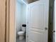 Toilet room featuring a toilet and a closed, white door at 2727 Harmonia Hammock Rd, Harmony, FL 34773