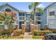 Inviting two-story condo with a beautiful blue exterior, lush landscaping, and a charming gated entrance at 2737 N Poinciana Blvd # 92, Kissimmee, FL 34746
