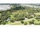 Aerial view of wooded lot with home nestled in the trees, nearby developments, and pond at 2810 Horton Rd, Kissimmee, FL 34744