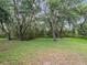 Spacious backyard featuring mature trees and lush greenery, perfect for outdoor activities at 2810 Horton Rd, Kissimmee, FL 34744