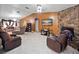 Open living room featuring tile floors, a stone fireplace, and earth-toned walls at 2810 Horton Rd, Kissimmee, FL 34744