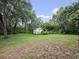Backyard featuring a storage shed surrounded by lush greenery and mature trees with Spanish Moss at 2810 Horton Rd, Kissimmee, FL 34744