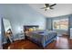 Stylish bedroom features wood floors, a ceiling fan, a mirror and a comfortable blue bed at 2867 Club Cortile Cir, Kissimmee, FL 34746