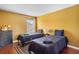 Bright bedroom featuring twin beds, hardwood flooring, and cheerful yellow walls at 2867 Club Cortile Cir, Kissimmee, FL 34746