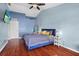 Stylish bedroom features wood floors, a ceiling fan, a mirror and a comfortable blue bed at 2867 Club Cortile Cir, Kissimmee, FL 34746