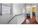 Upstairs hallway with wood floors leading to a bright bedroom with a window at 2867 Club Cortile Cir, Kissimmee, FL 34746