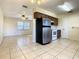 Open-concept kitchen featuring stainless steel appliances and tile flooring, flowing into a bright living area at 430 Short Dr, Kissimmee, FL 34759